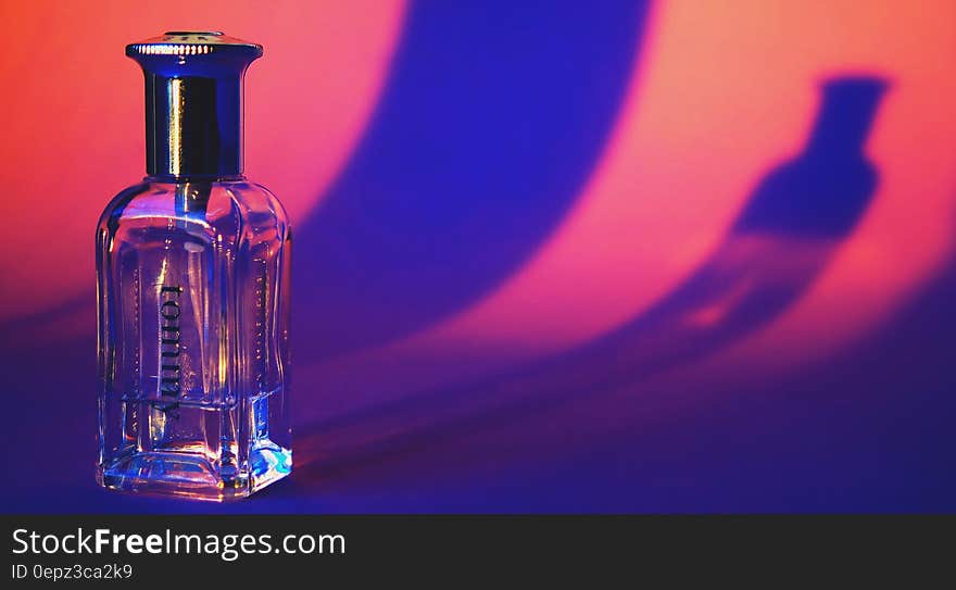 A close up of a transparent half empty perfume bottle.