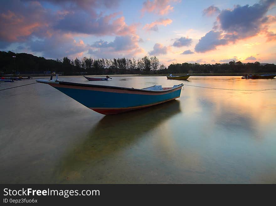 Wooden boat moored on waterfront at sunset. Wooden boat moored on waterfront at sunset.