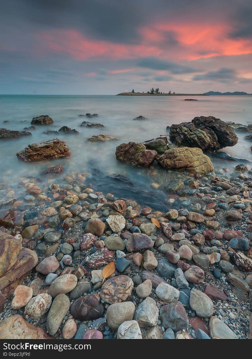 A beach with small and large rocks at sunset. A beach with small and large rocks at sunset.