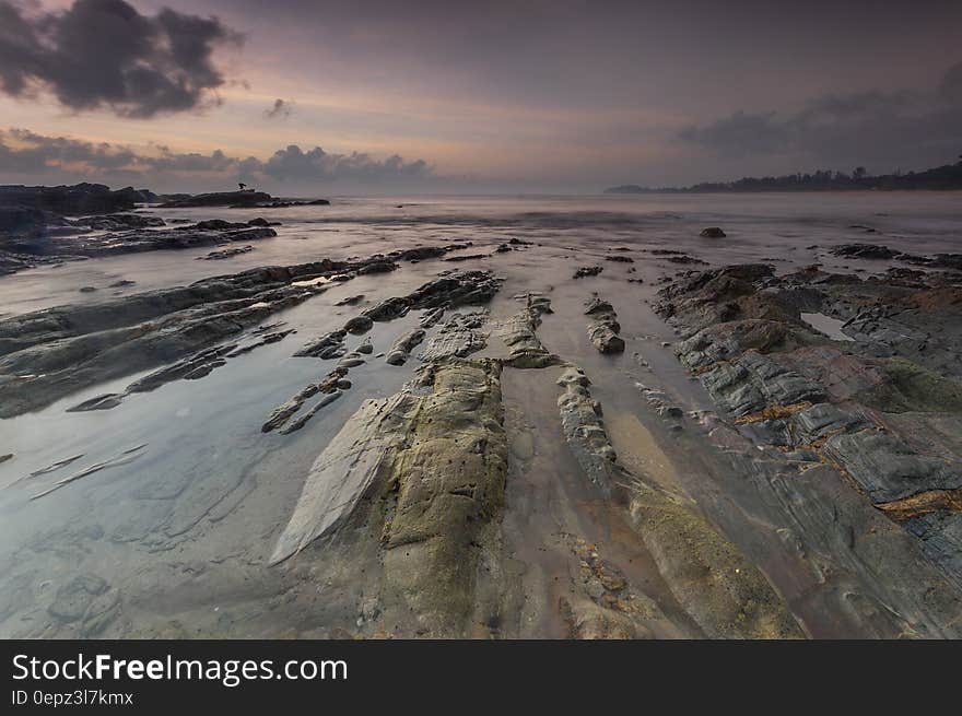 The sunset on the seashore with tide revealing rocks. The sunset on the seashore with tide revealing rocks.