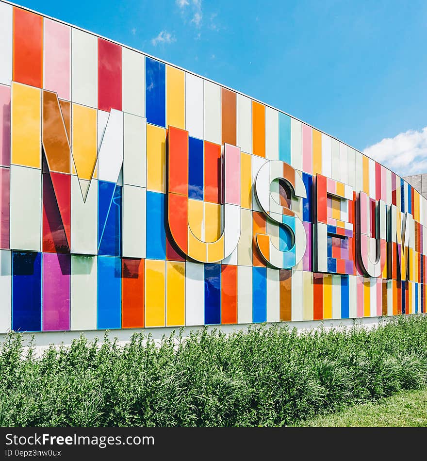 Colorful tiles spelling museum on outside of building against blue skies on sunny day. Colorful tiles spelling museum on outside of building against blue skies on sunny day.