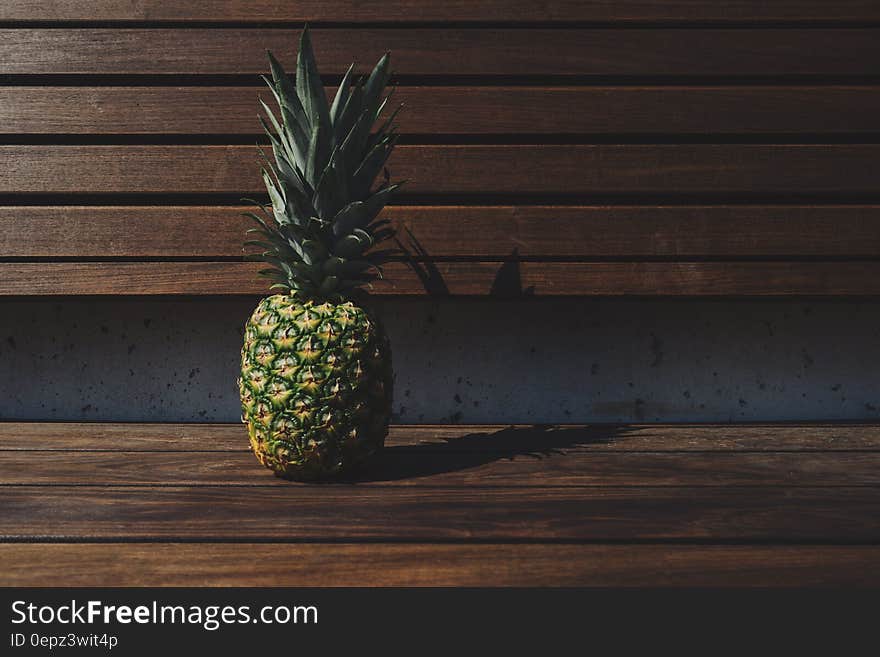 Fresh ripe whole pineapple fruit on wooden bench. Fresh ripe whole pineapple fruit on wooden bench.