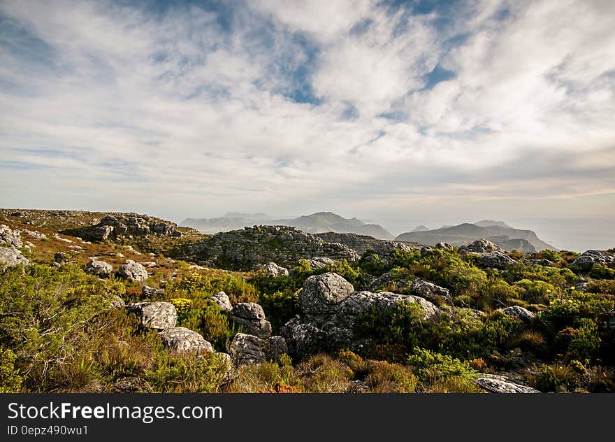 Rocky hillside against blue skies with clouds on sunny day. Rocky hillside against blue skies with clouds on sunny day.