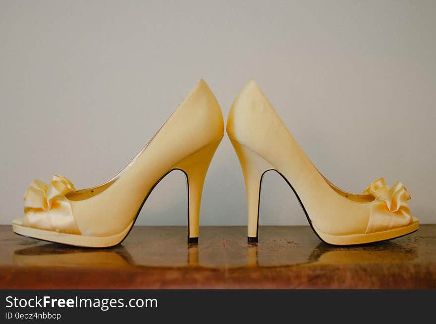 Close up of high heel yellow leather shoes on wood. Close up of high heel yellow leather shoes on wood.