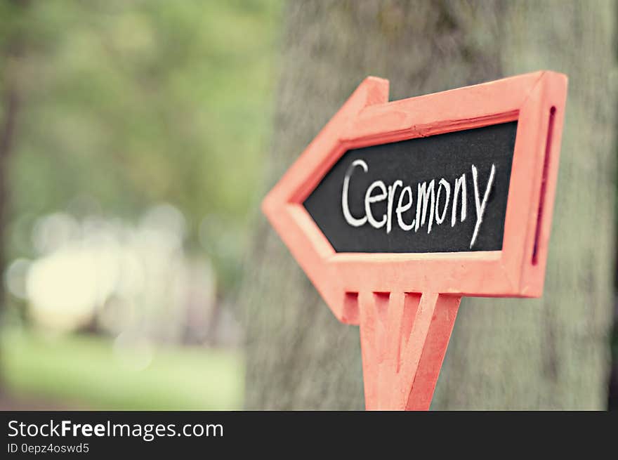 A sign with the word ceremony pointing towards the wedding ceremony. A sign with the word ceremony pointing towards the wedding ceremony.