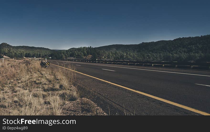 Empty road through countryside on sunny day.