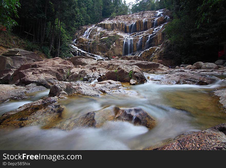 Waterfall over cliff and rocky stream in forest. Waterfall over cliff and rocky stream in forest.