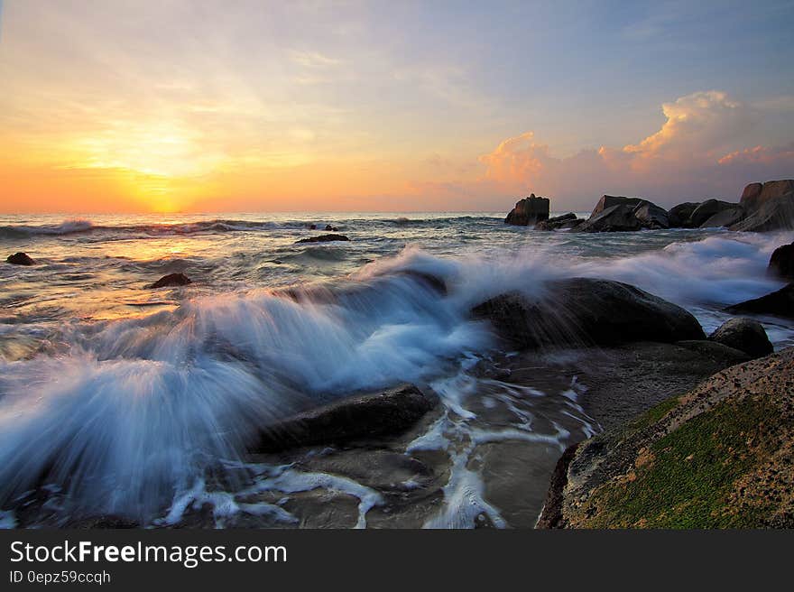 Waves splashing over rocky shores at sunrise. Waves splashing over rocky shores at sunrise.