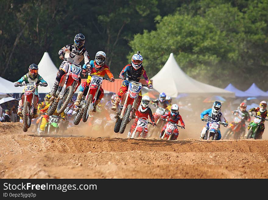 Motocross bikers crossing an obstacle on the track. Motocross bikers crossing an obstacle on the track.