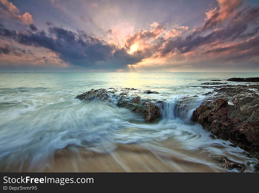 A long exposure on a rocky shore with sunset. A long exposure on a rocky shore with sunset.