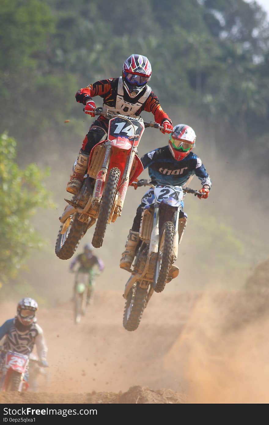 A motocross race with motorbikers jumping over an obstacle. A motocross race with motorbikers jumping over an obstacle.