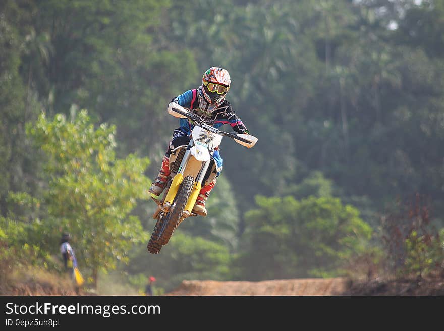 A motocross racer jumping over an obstacle.