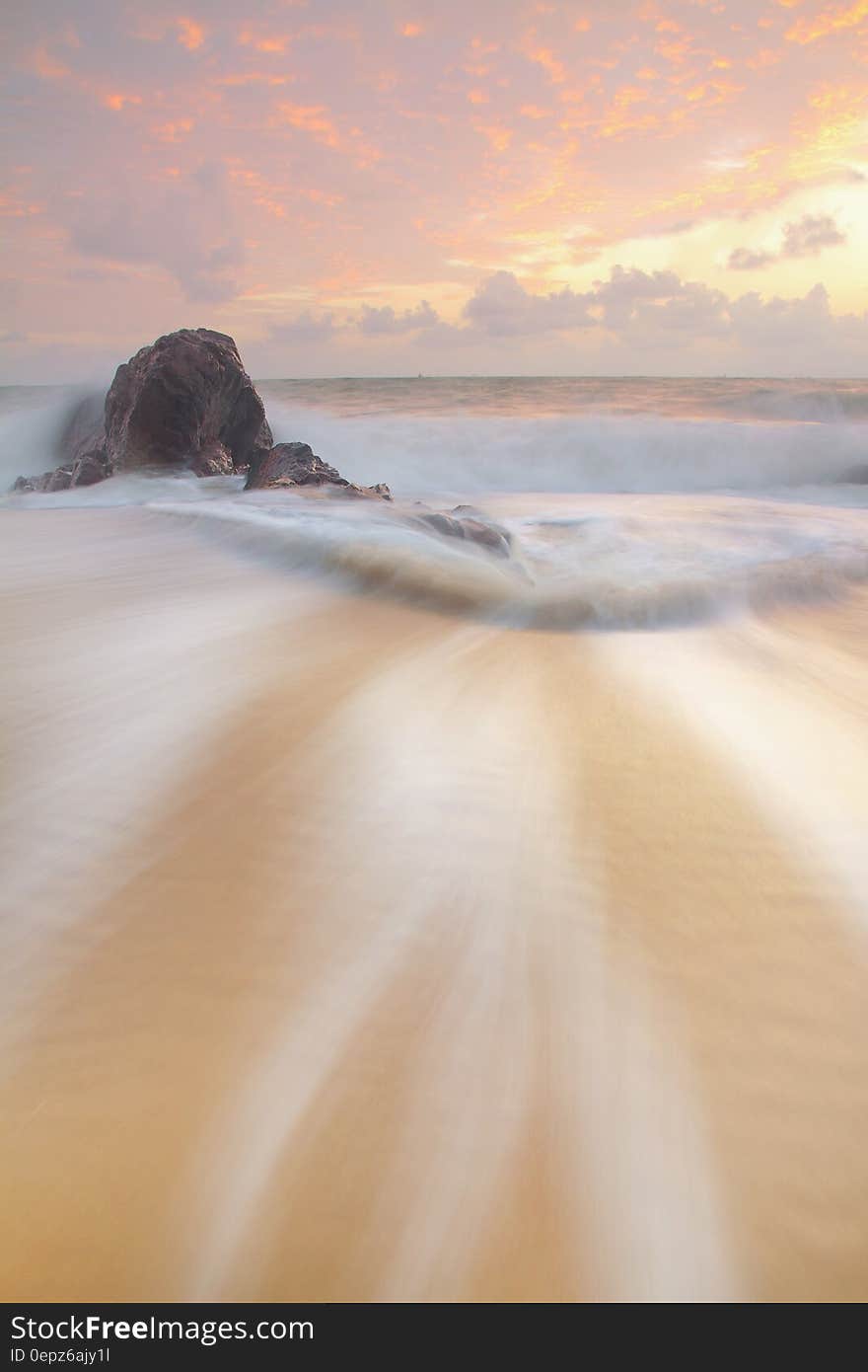 Brown Sand Beside Brown Rock during Daytime