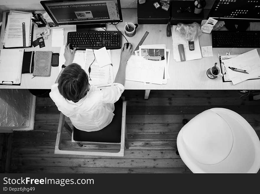 Black and Gray Photo of Person in Front of Computer Monitor