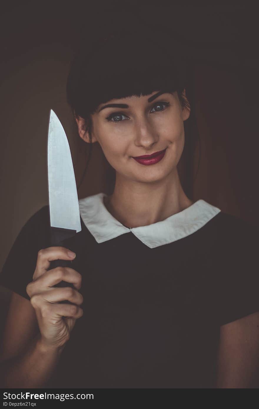 A woman holding a kitchen knife. A woman holding a kitchen knife.