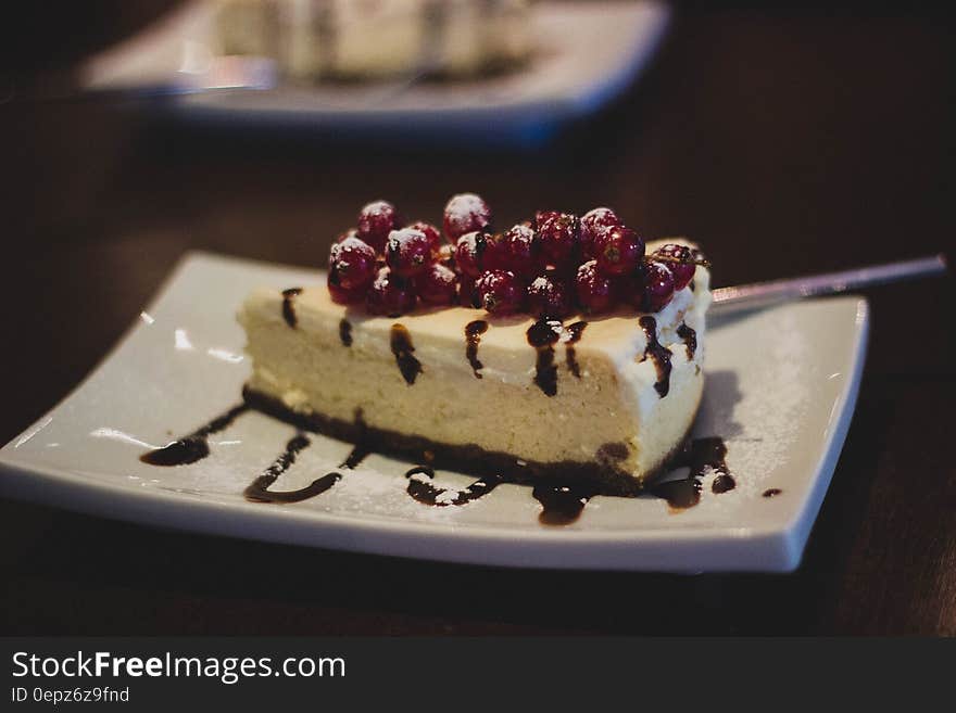 A cake with red currants and chocolate sauce.