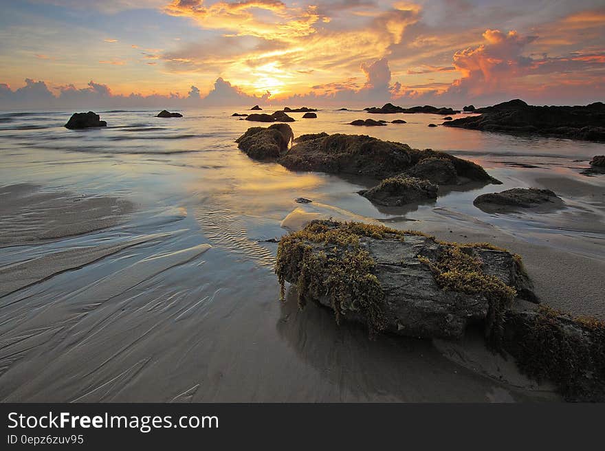 Sea Rock Under White Clouds Blue Skies during Sunset