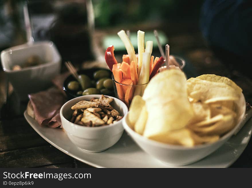 Tray of bowls with chips, snack mix, olives and crudites. Tray of bowls with chips, snack mix, olives and crudites.