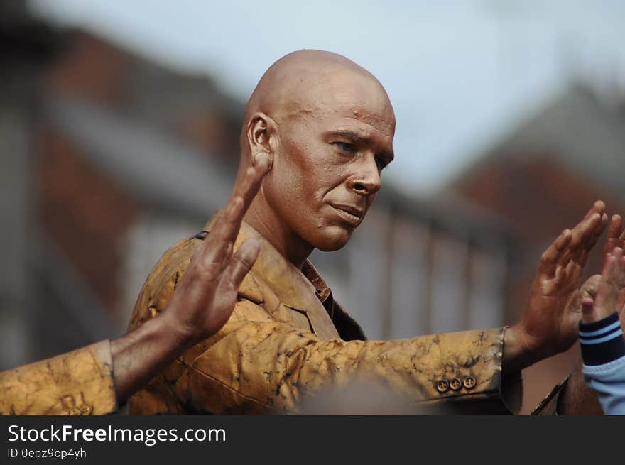 Close up portrait of Indian man with gold jacket greeting child with high five gesture. Close up portrait of Indian man with gold jacket greeting child with high five gesture.