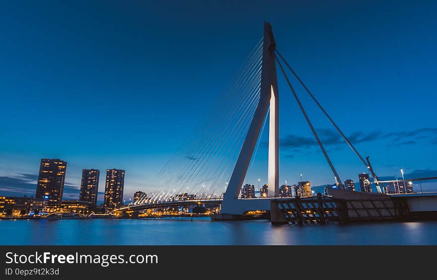 Suspension bridge over urban river at twilight. Suspension bridge over urban river at twilight.