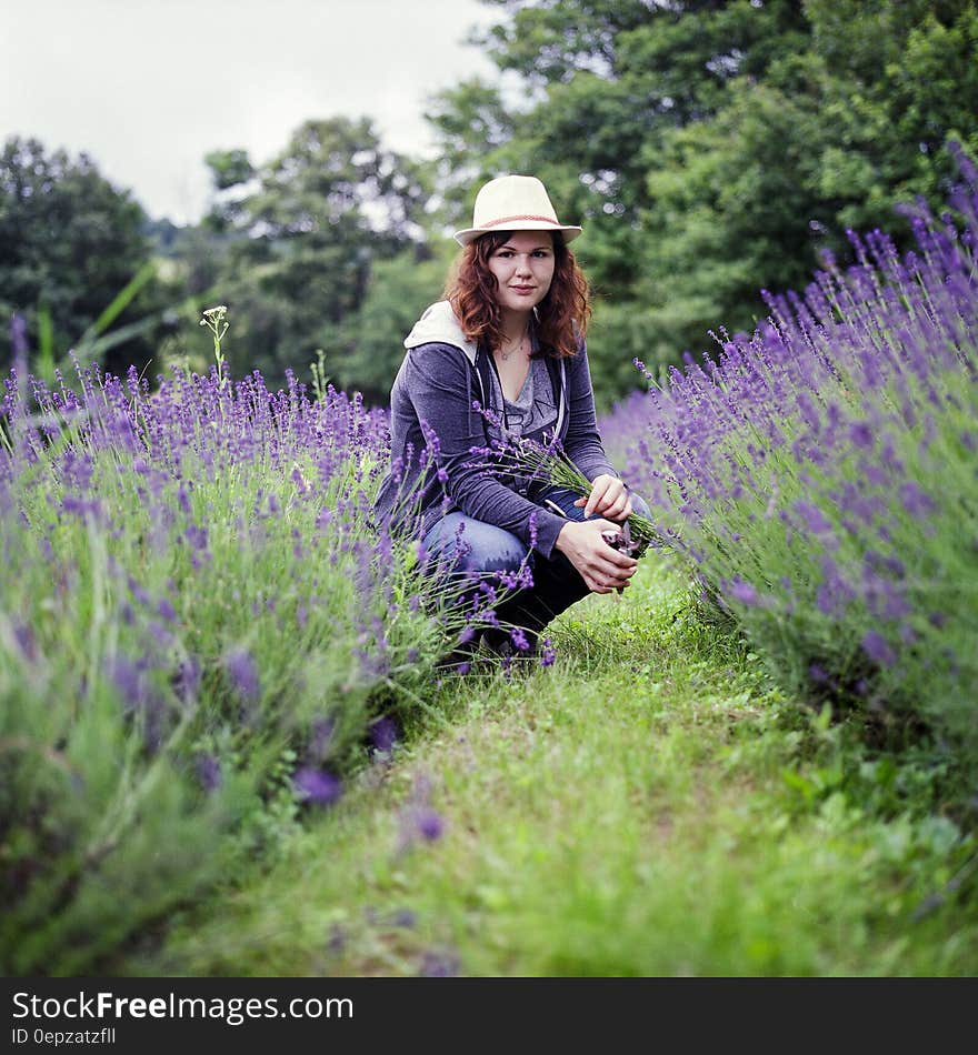 Woman Wearing Purple Jacket in Brown Hat during Day Time