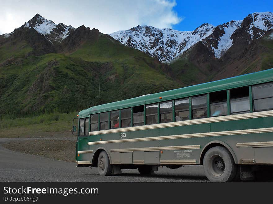 Bus on roadway in mountains on sunny day. Bus on roadway in mountains on sunny day.