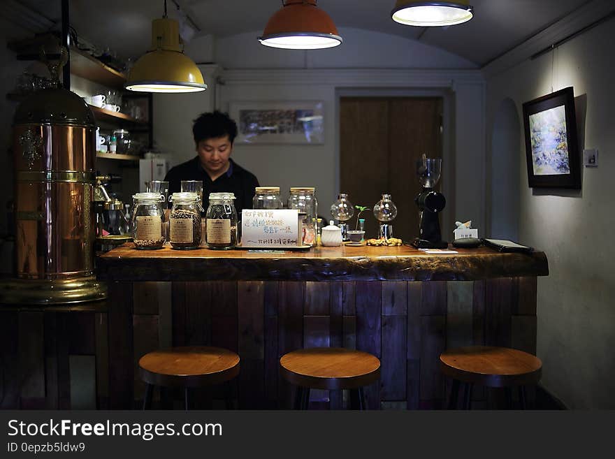 Man on Black Polo Shirt Is Standing Infront of Bar Counter