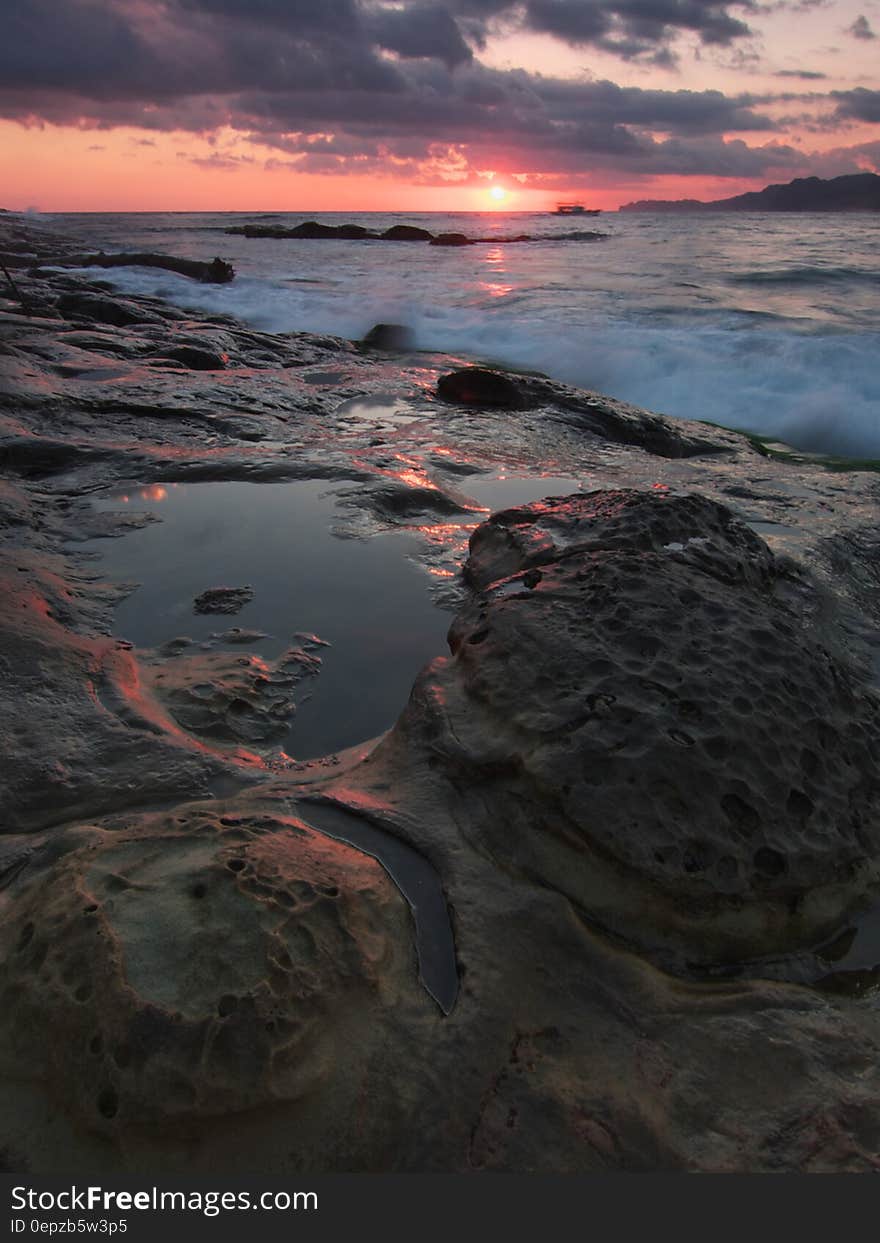 Gray and Black Rock Formation Near the Ocean during Sunset