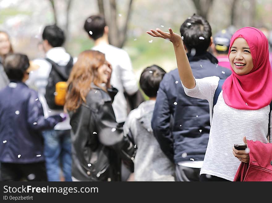 Woman Wearing Red Hijab Behind Person Wearing Black Jacket