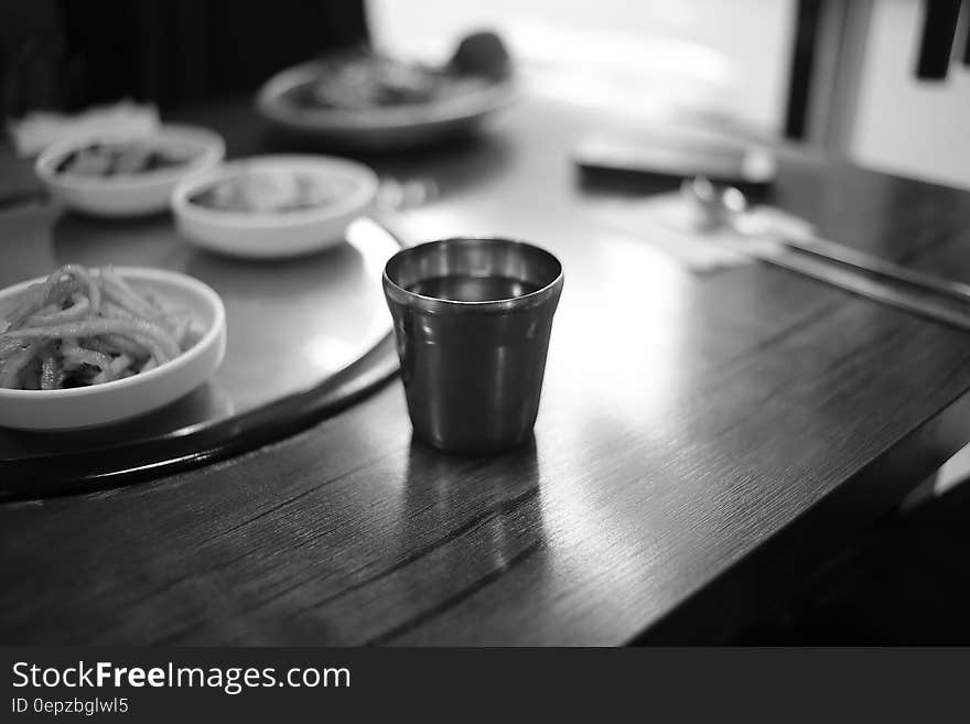 Stainless Steel Cup on Brown Wooden Top Table