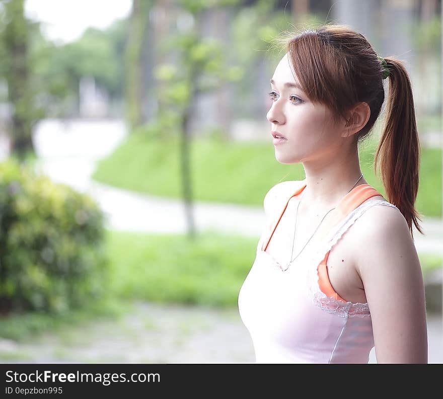 Woman in White Tank Top With Green Leafed Plant during Daytime in Tilt Shift Photography