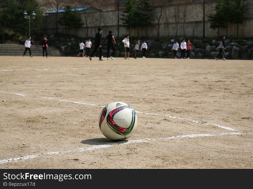 White Red and Green Ball Near Group of People Playing Soccer