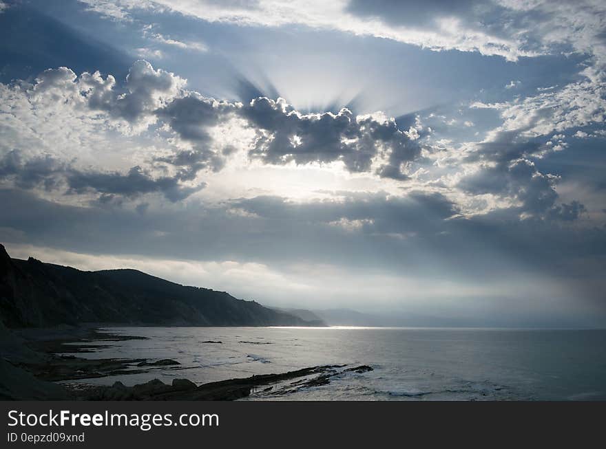 Blue Calm Water Near Mountain during Daytime