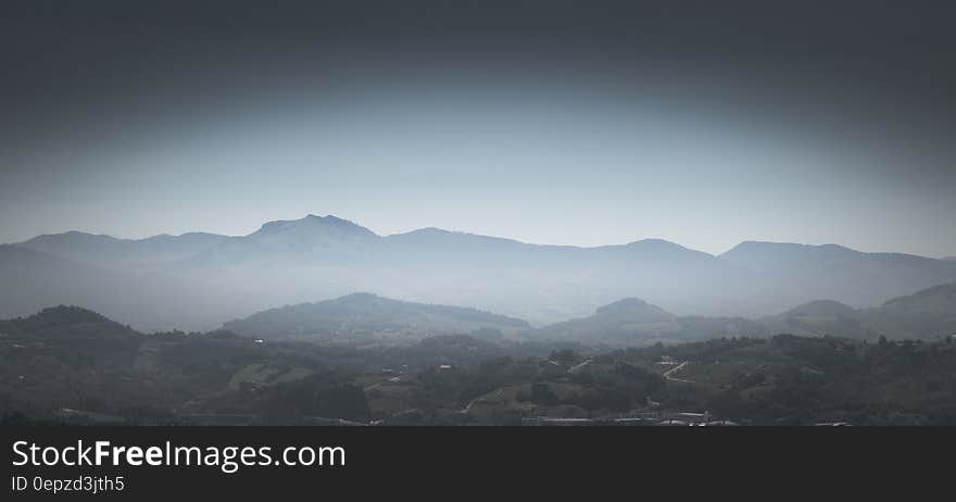 Greyscale Photo of Mountains With Mist