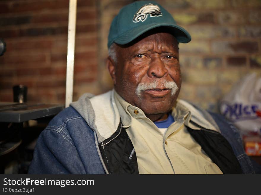 Portrait of senior man in jean jacket wearing Philadelphia Eagles hat. Portrait of senior man in jean jacket wearing Philadelphia Eagles hat.