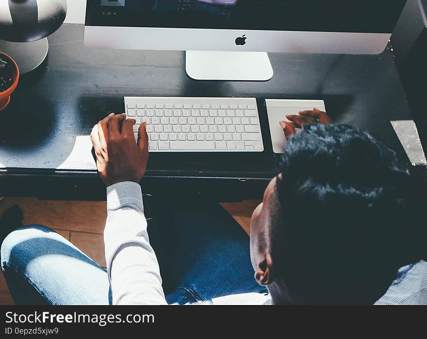 Man in White Dress Shirt Facing Turned on Silver Imac