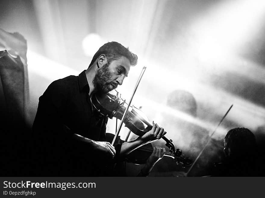 Man on stage playing violin in concert in black and white. Man on stage playing violin in concert in black and white.