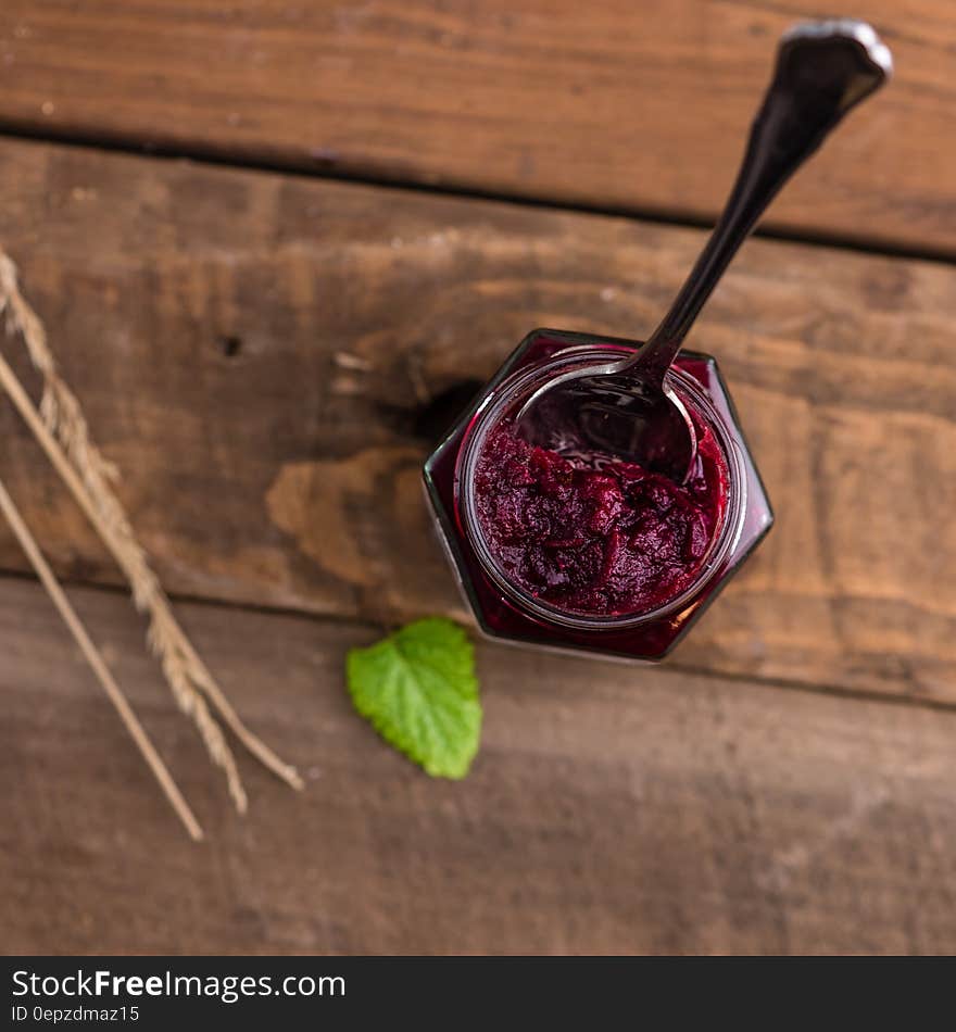 Silver Spoon on Red Syrup in Top View Photography