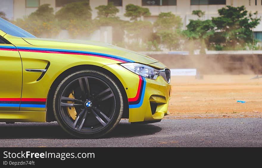 Front of BMW M4 car on road on sunny day.