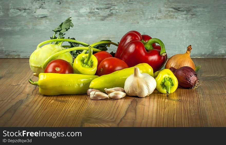 Garlic Beside Ginger and Pepper on Brown Wooden Table