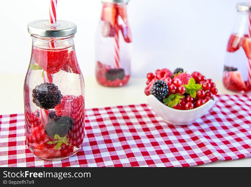 Red Cherry and Grapes on Clear Glass Bottle