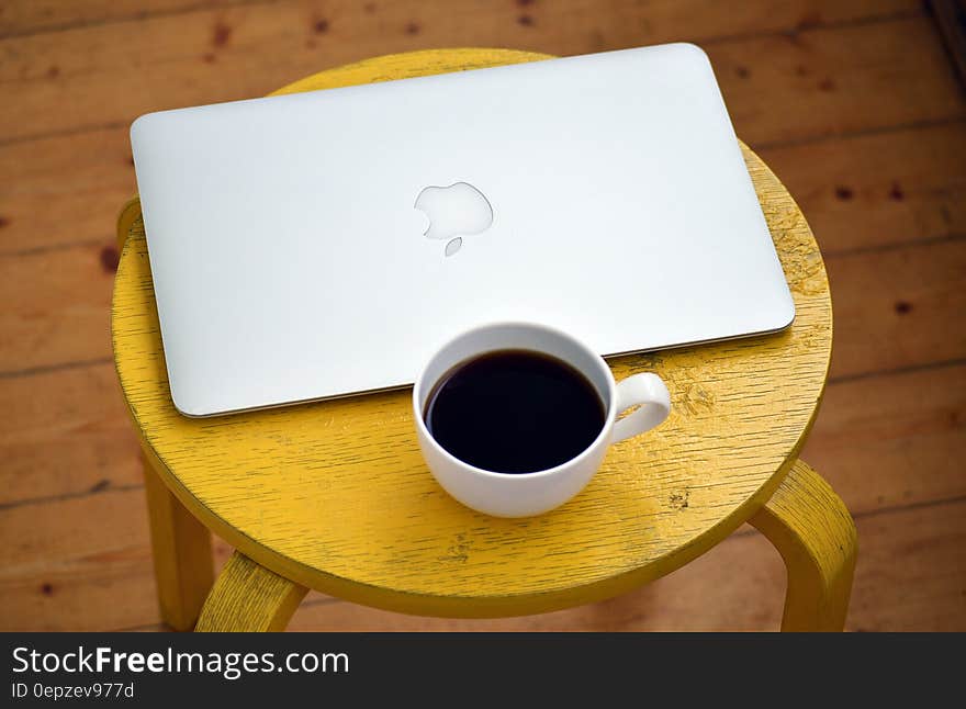 Silver Macbook Beside White Cup