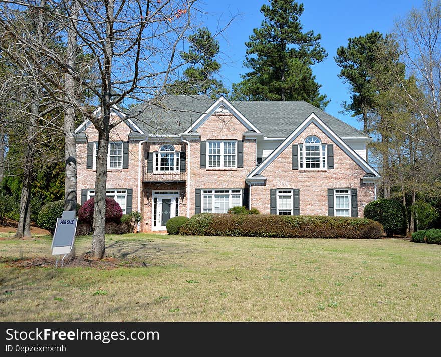 Gray and Brown House Behind Green Grass during Daytime