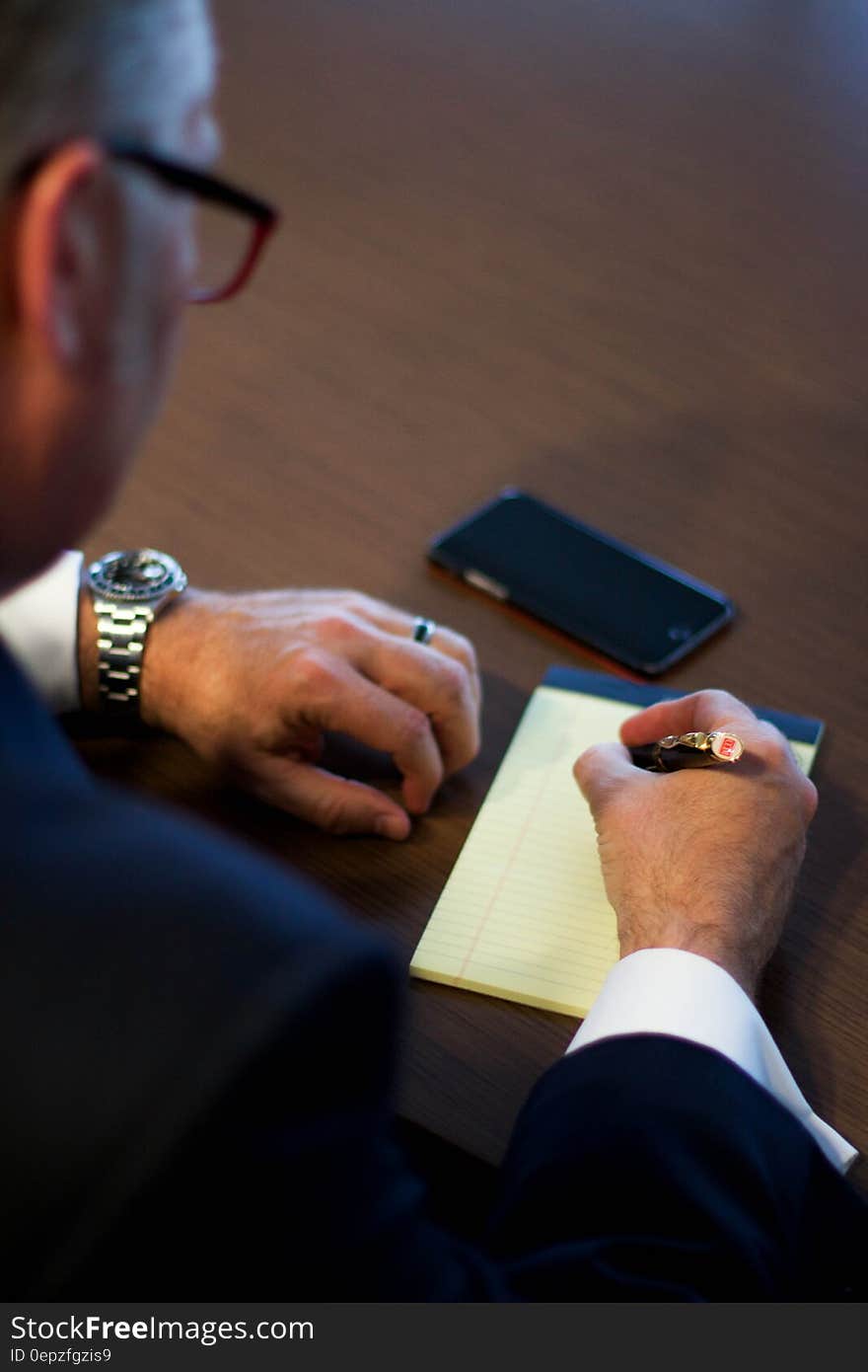 Person Writing Notes on White Ruled Paper