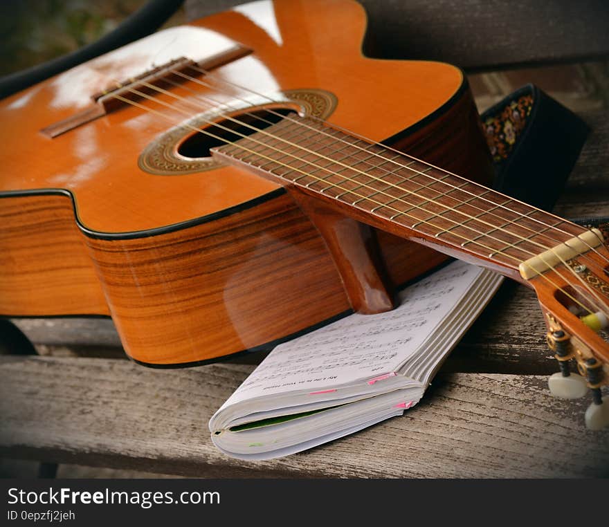 Brown Acoustic Guitar on White Music Note Book