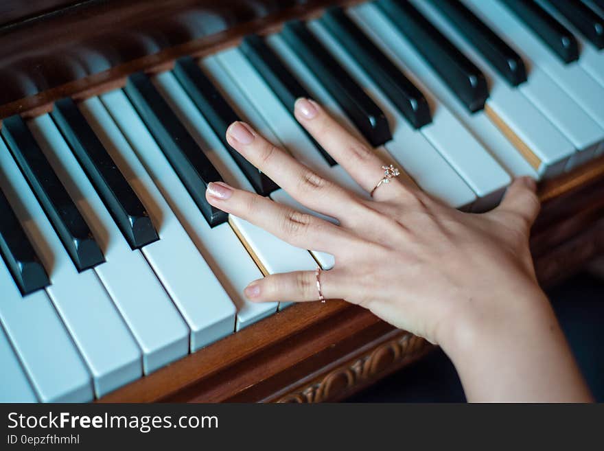 Brown Wooden Piano Used by a Person Using 2 Fingers