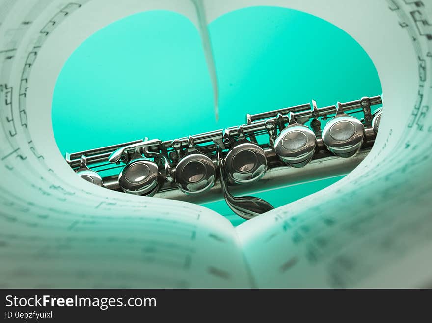 Music Note Book and Silver Soprano Flute Close Up Photography