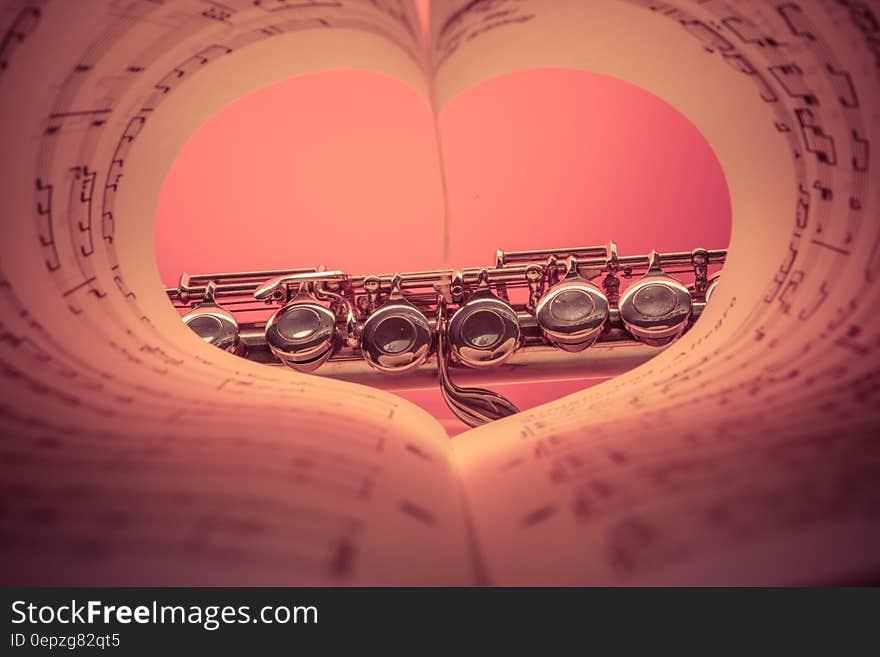 Chrome Musical Instrument Viewed on Heart Shaped Music Score Book