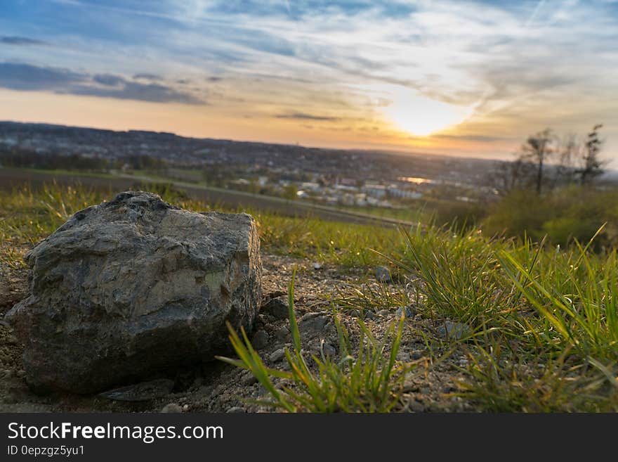 Gray Stone on Grassy Field during Under Cloudy Sky during Sunset