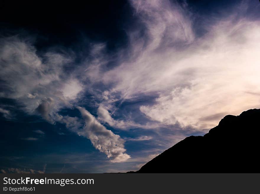 Silhouette of Mountain Under White Clouds